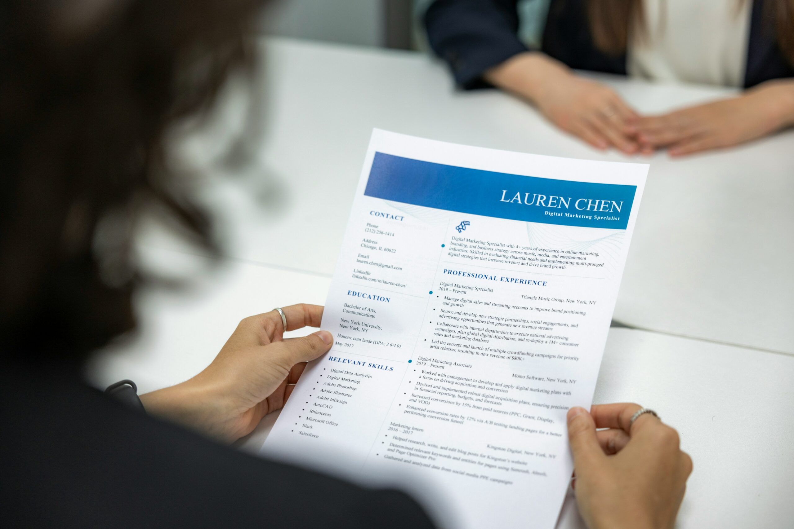 Donna che tiene in mano un CV, Foto di Resume Genius su Unsplash.