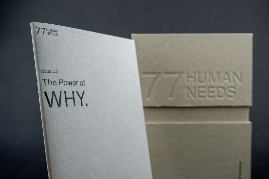 Copertina di un libro bianca con la scritta "The Poer of WHY" Foto di The 77 Human Needs System su Unsplash