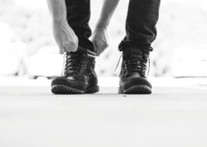 Persona che si allaccia le scarpe pronta ad iniziare il percorso. Foto di Alex Jones su Unsplash