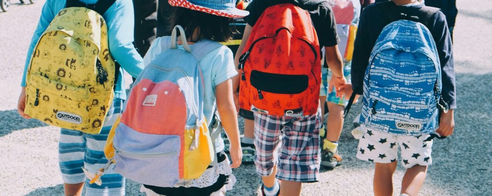 note-thanun-CYlPykF-qAM-unsplash Scolaresca di bambini di spalle con zaini colorati. Foto di note thanun su Unsplash